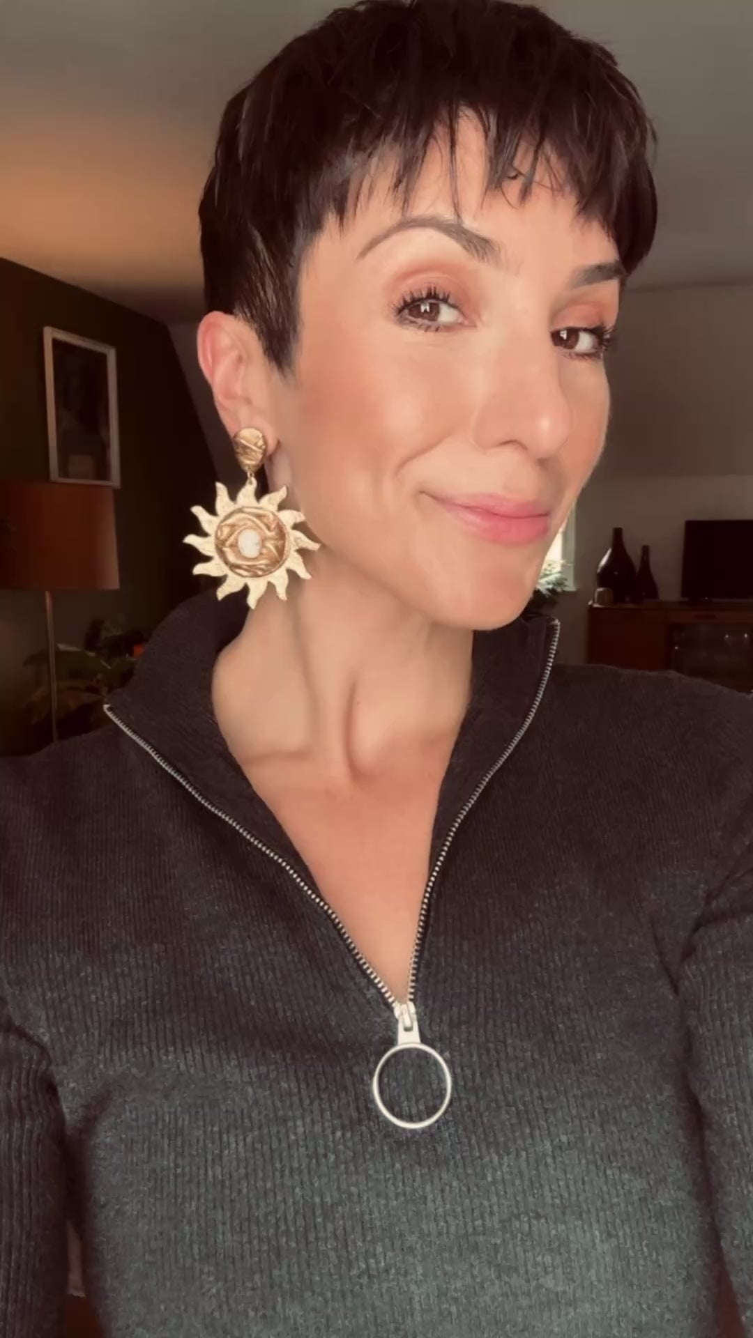 Model wearing Ava & Azar handcrafted gold statement earrings blazing sun draped with white Howlite semi precious stones
