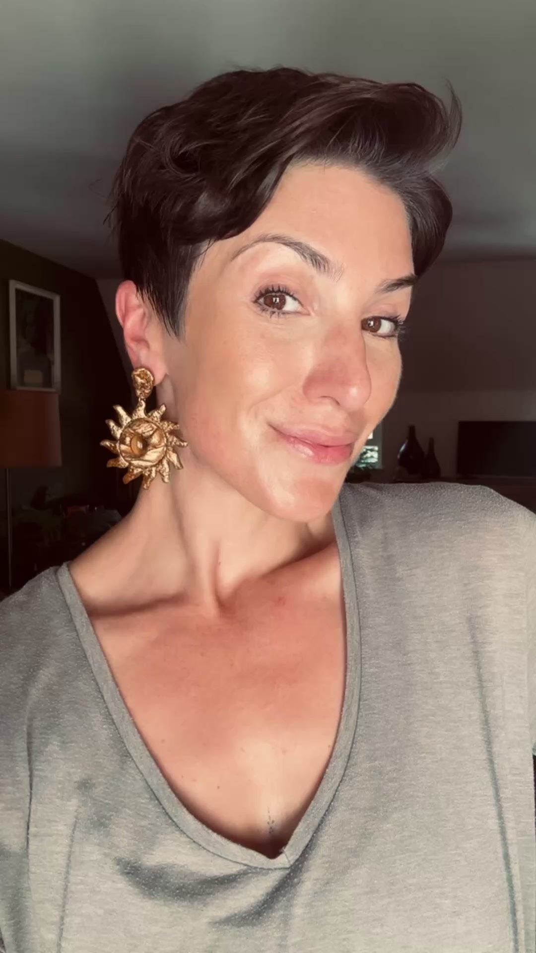 Model wearing Handcrafted draped sun statement earring, sculpted with tigers eye cabochons