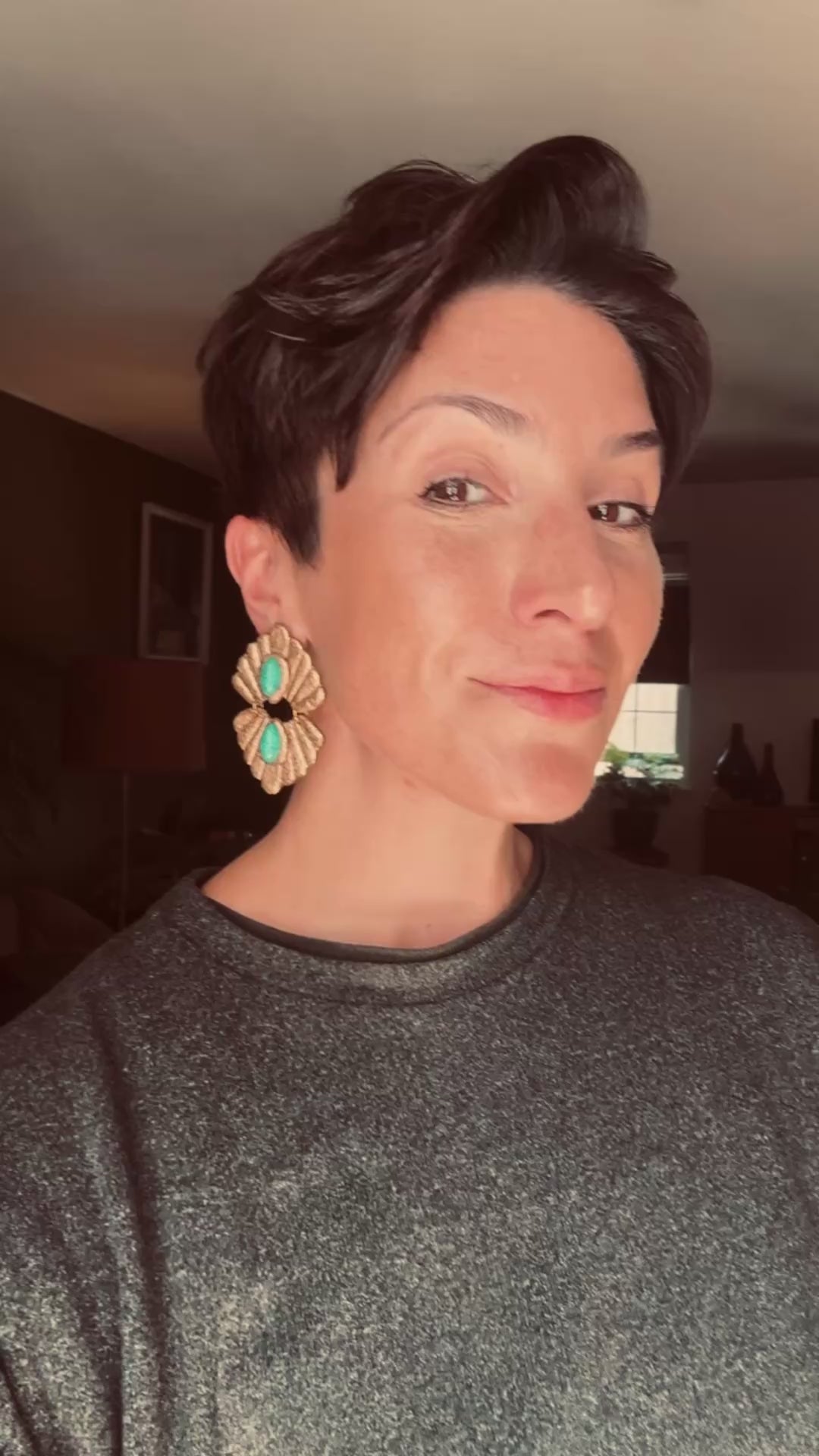 Model wearing Ava & Azar handcrafted Caspian Gold and Turquoise Howlite statement earrings