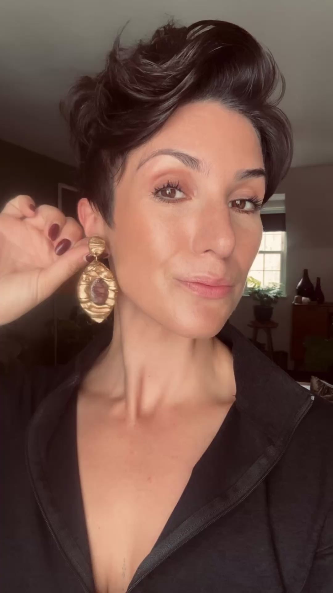 Model wearing Ava & Azar handcrafted statement gold earrings with maroon mookaite jasper stones