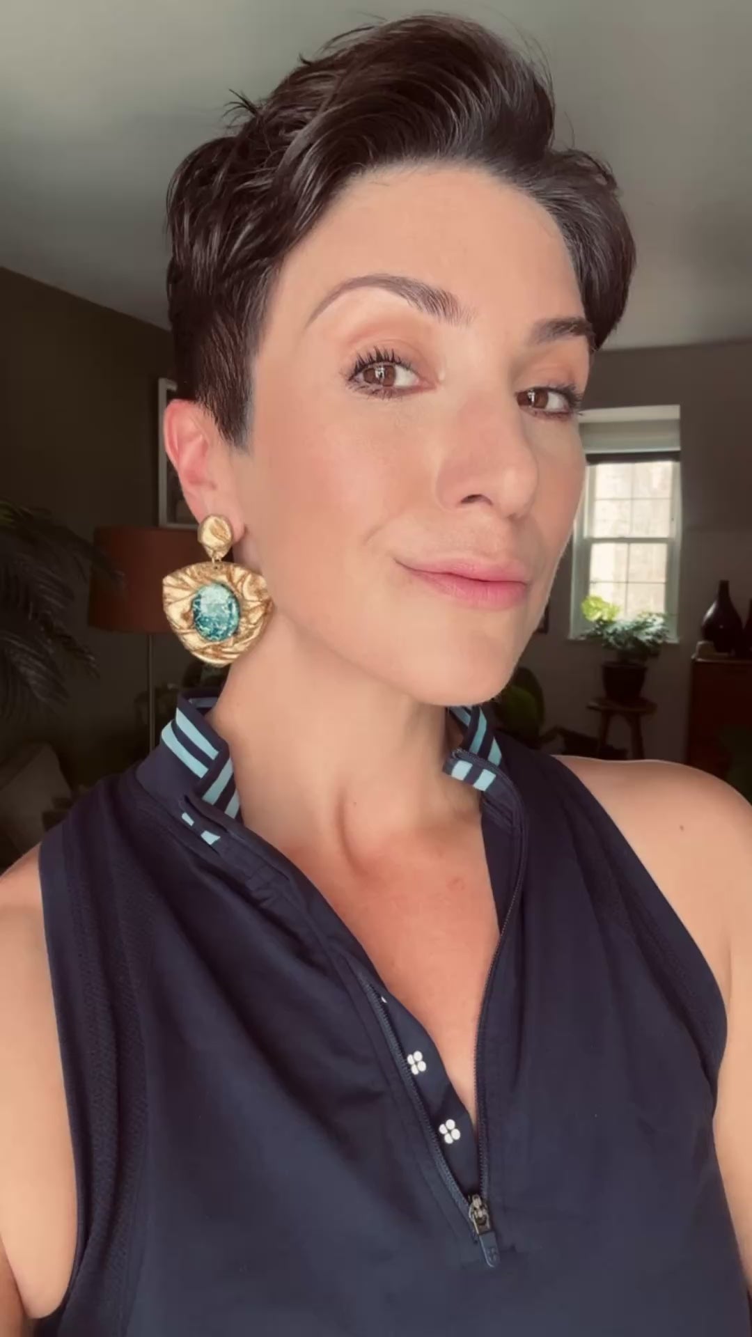 Model wearing Ava & Azar handcrafted gold draped earrings with azurite Shattuckite stones 