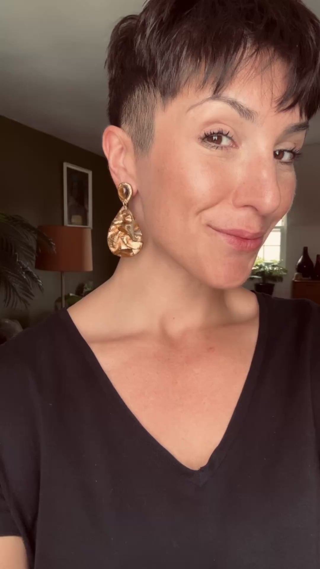 Model wearing the Ava & Azar draped Tiger’s Eye handcrafted statement earrings
